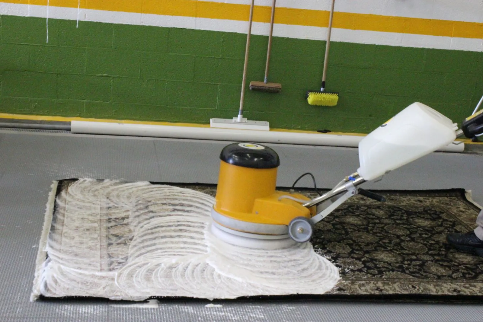 Rug scrubbed with a gentle rotary shampoo brush on the wash floor