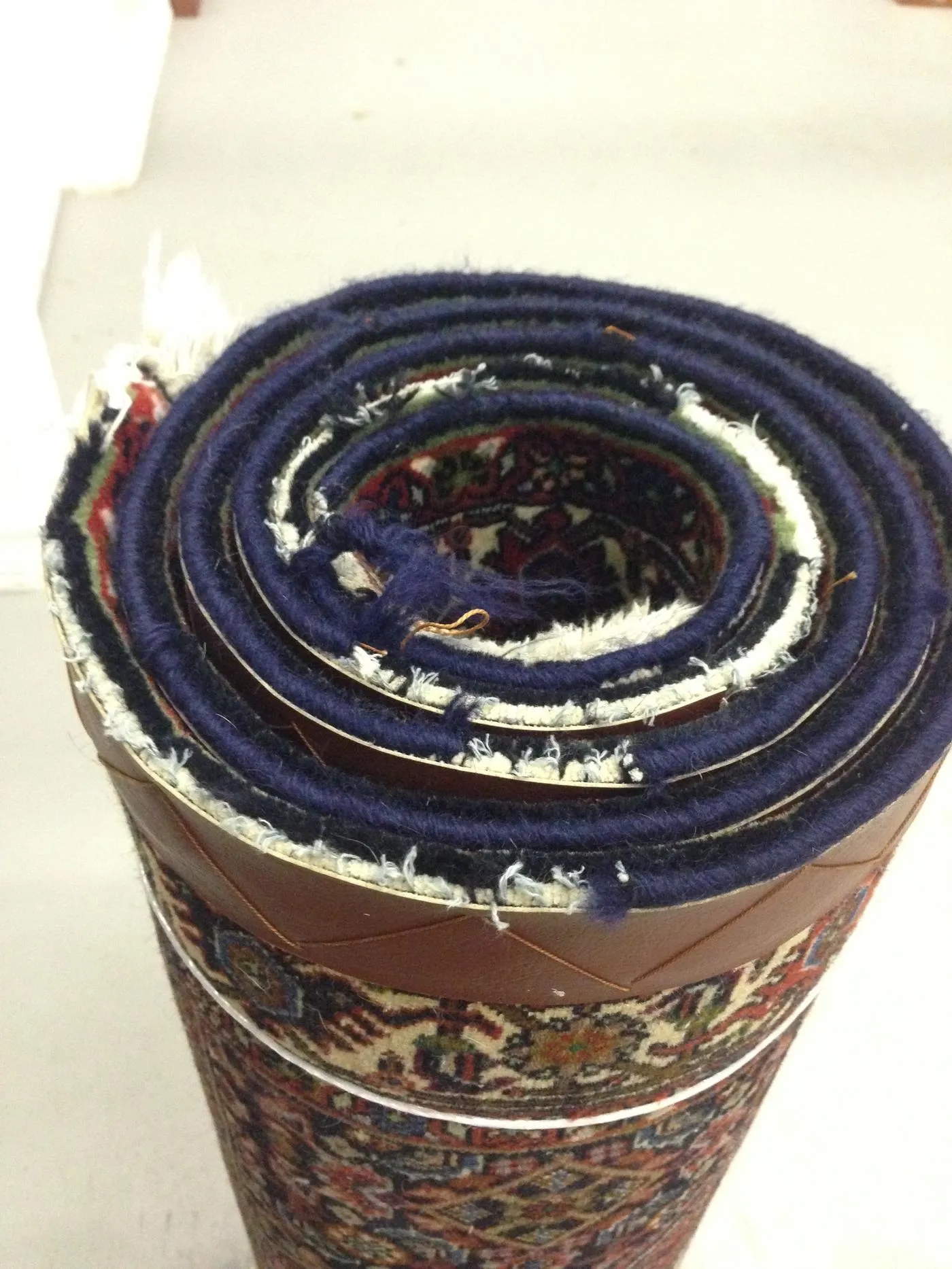 Worn, frayed side edge of a rug before hand repair
